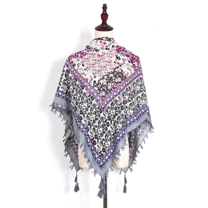 Detailed close-up of bohemian floral paisley pattern scarf with elegant grey fringe trim