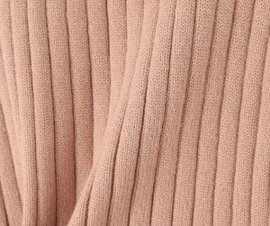 Close-up of pink ribbed knit fabric texture showing high-quality woven material detail