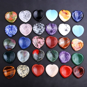 Assorted natural crystal heart thumb stones in various vibrant colors on black background