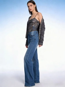 Modella professionale indossa jeans in denim blu a vita alta e gamba larga vista di profilo