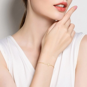 Minimalist 925 sterling silver golden cross bracelet worn on female wrist for daily style