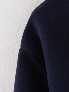 Detailed macro shot of navy blue wool jacket shoulder seams and warm textured fabric