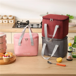 Waterproof insulated lunch bags in pink, red, and grey with comfortable web handles