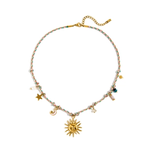 Flat lay of colorful braided rope necklace with golden sun, moon and star charms