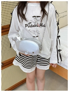Silver dolphin-shaped crossbody bag shown as part of a stylish outfit for kids