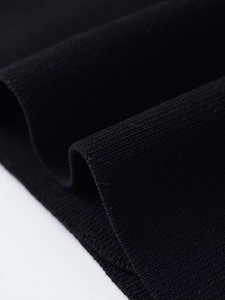 Detailed close-up of premium black rib-knit fabric texture and weaving craftsmanship