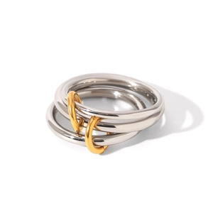Macro view of triple interlocking stainless steel rings with gold links on white backdrop