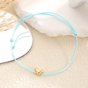 Bracelet tressé bleu clair ajustable avec pendentif cœur doré sur décor de pierre