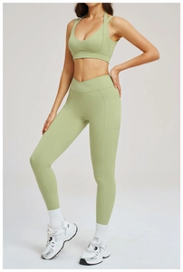 Dettaglio dei leggings da yoga verde oliva con vita a incrocio e tasca laterale