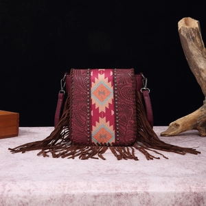Detail of vintage bohemian crossbody bag with wine red leather and decorative fringe