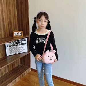 Soft pink plush puppy shoulder bag for kids shown on model in cozy home setting