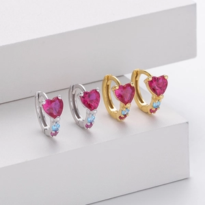 Macro shot of s925 silver heart hoop earrings with colorful gemstones in gold and silver