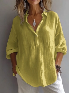 Détail d'une chemise jaune en lin à manches longues avec col en V et coupe décontractée