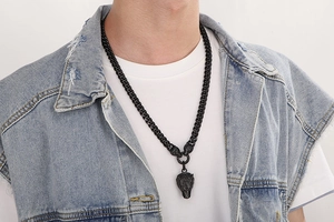 Close-up of men's punk wolf head necklace with thick chain on model in white t-shirt