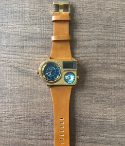 Detailed close-up of brown leather strap with golden Oulm buckle on wood background