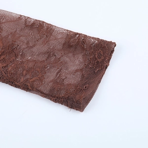 Gros plan sur la dentelle marron foncé montrant la texture du mesh et les broderies