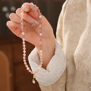 Handmade strawberry quartz and freshwater pearl bracelet with a gold strawberry pendant