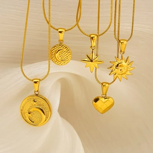 18K gold-plated stainless steel necklaces with sun, moon, and heart charms on white fabric