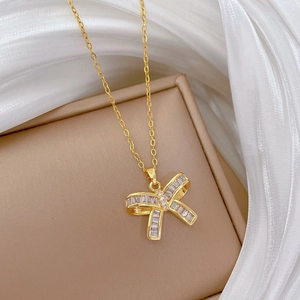 Close-up of golden butterfly pendant featuring sparkling rectangular zircon stones
