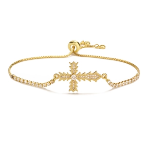 Adjustable gold cross bracelet with shimmering cubic zirconia stones on white background