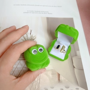 Detail view of frog-shaped green flocking jewelry box with ring storage insert