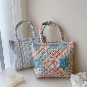 Quilted floral and checkered cotton tote bags featuring a simple wish label on plain wall