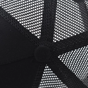 Detailed close-up of the black mesh fabric and top button on a breathable baseball cap
