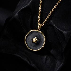 Macro detail of a gold-plated celestial star pendant with black enamel texture