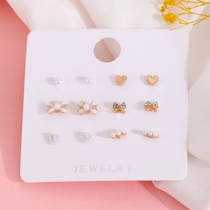 Set de 6 pares de pendientes con perlas, corazones dorados y lazos en cartulina