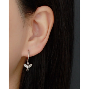 Macro detail of S925 sterling silver peace dove hoop earrings with black beads