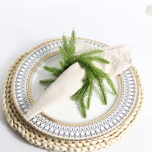 Norfolk pine wreath napkin ring with green spruce branch on a rustic table setting