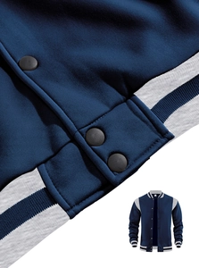 Close-up of navy varsity jacket featuring matte snap buttons and striped ribbed hem details