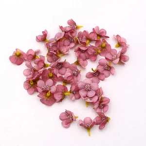 Detail shot of 2cm mini pink artificial silk daisy heads with yellow pistils for DIY crafts