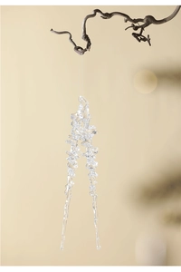 Macro shot of clear acrylic icicle ornaments hanging on branches for winter decor