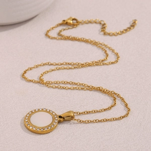 Detail view of 18K gold plated necklace with diamond-encrusted shell pendant and chain