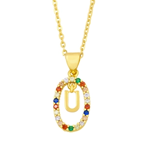 Macro shot of gold oval pendant featuring a pavé colored zircon border and letter U