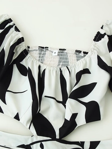 Flat lay of a floral print square neck dress with black and white leaf patterns