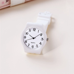 Close-up of minimalist white quartz watch face with black Arabic numerals and silicone strap
