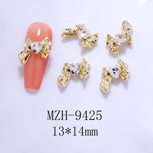 Detailed view of golden bow nail art charms with heart crystals and 13*14mm dimensions