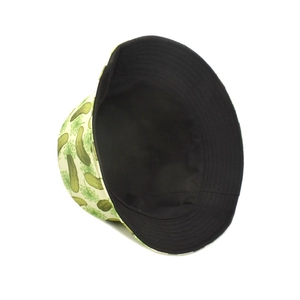 Detail showing reversible bucket hat with green cucumber print and black inner lining