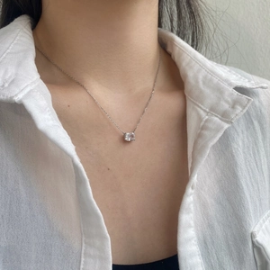 Detail of square-cut clear gemstone pendant on S925 silver chain worn on model