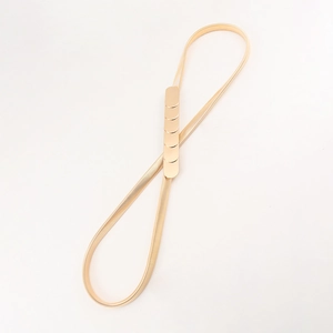 Detailed close-up of golden flat snake chain stretch belt with minimalist clasp closure