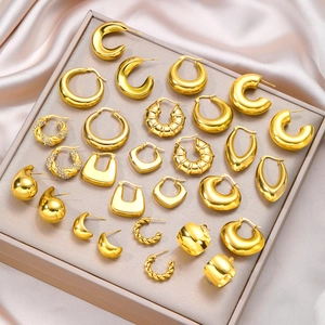 Detailed close-up of various gold plated geometric hoop earrings on a beige jewelry tray