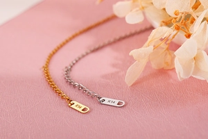 Macro view of gold and silver extensions with K14 engraving on stainless steel bracelet
