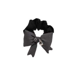 Elegante elastico in tessuto con fiocco grigio, sfera di strass e ciondolo in metallo