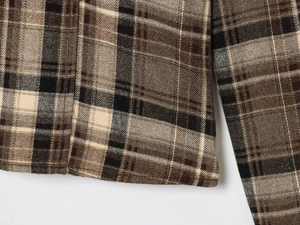 Macro view of plaid pattern fabric on the shirt hem and cuffs showing weave detail