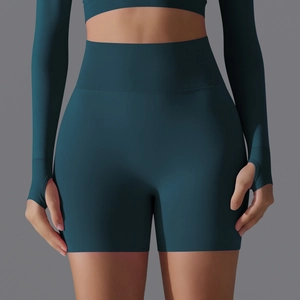 Detail of dark green seamless yoga set with ribbed high-waisted shorts and thumbhole cuffs