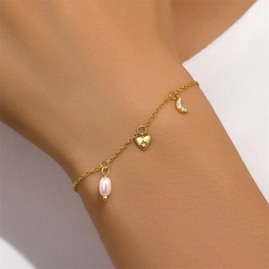 Detailed shot of golden S925 sterling silver bracelet with heart, moon and pearl charms