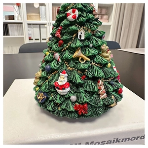 Detailed view of handcrafted green Christmas tree music box with festive ornaments