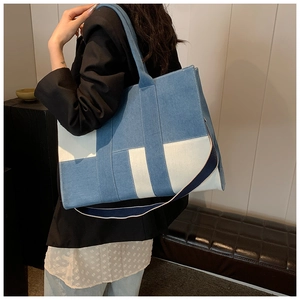 Detail of blue denim and white canvas patchwork tote bag showing large capacity size